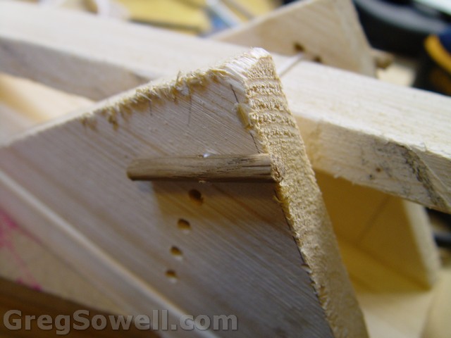 Twine run from one dowel through the holes - either side of launch arm - through holes and into the last drilled dowel.